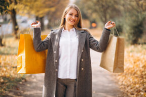 Femme heureuse consultant son ordinateur pour trouver des Codes Promo Exclusifs et bons plans afin d’économiser en 2025