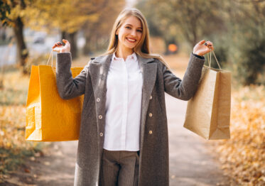 Femme heureuse consultant son ordinateur pour trouver des Codes Promo Exclusifs et bons plans afin d’économiser en 2025