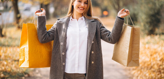 Femme heureuse consultant son ordinateur pour trouver des Codes Promo Exclusifs et bons plans afin d’économiser en 2025